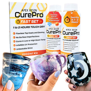 A product display for the Apex Resin CurePro Fast Set 1000ml kit, showing the product packaging boxes and hanging tags alongside a finished cup and tumbler held by hands. The glassware is decorated with swirls of blue, purple, and white resin on one, and a black and white moon and star pattern with glitter on the other.