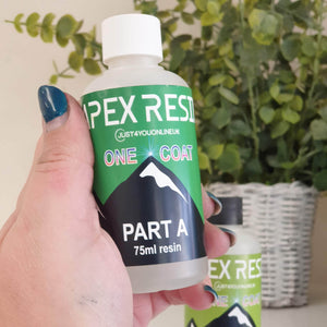 Hand holding a bottle of Apex Resin One Coat with green and black label.