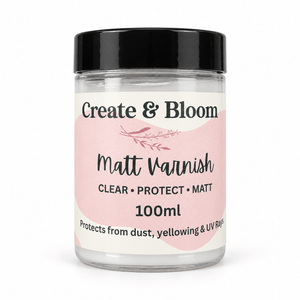 A 100ml jar of Create & Bloom Matte Varnish with a black lid and a pink and white label, set against a plain white background.