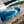 Resin Artistic depiction of a coastal scene with blue water, sand, and greenery.