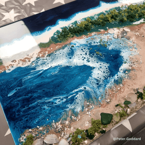 Resin Artistic depiction of a coastal scene with blue water, sand, and greenery.